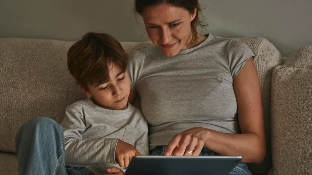 Platformă educațională potrivită — părinte și copil alegând împreună o aplicație pe tabletă